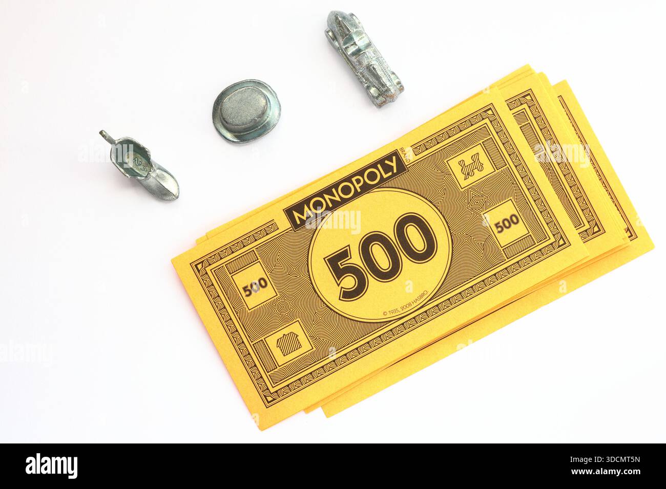 Monopoly Monopoly Money. banconota da 500 contanti con gettoni metallici, scarpe, cappello e auto. Foto sopra l'angolo. Foto Stock