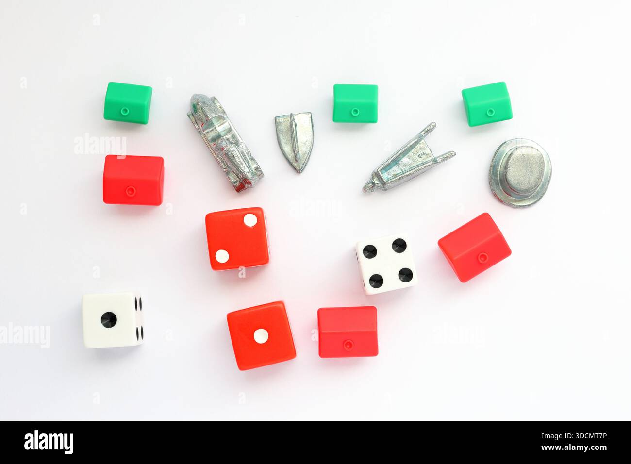 Gettoni di gioco Monopoli diversi. Dadi rossi e bianchi, hotel, case, auto in metallo, ferro da stiro, carriola, cappello. Foto Stock
