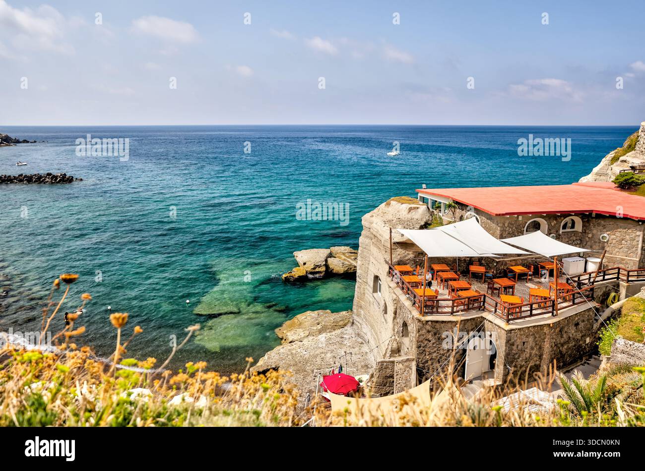 Terrazze e giardini sulla scogliera che si affacciano sulle acque turchesi nel villaggio di Sant'Angelo, Ischia, Campania, Italia. Foto Stock