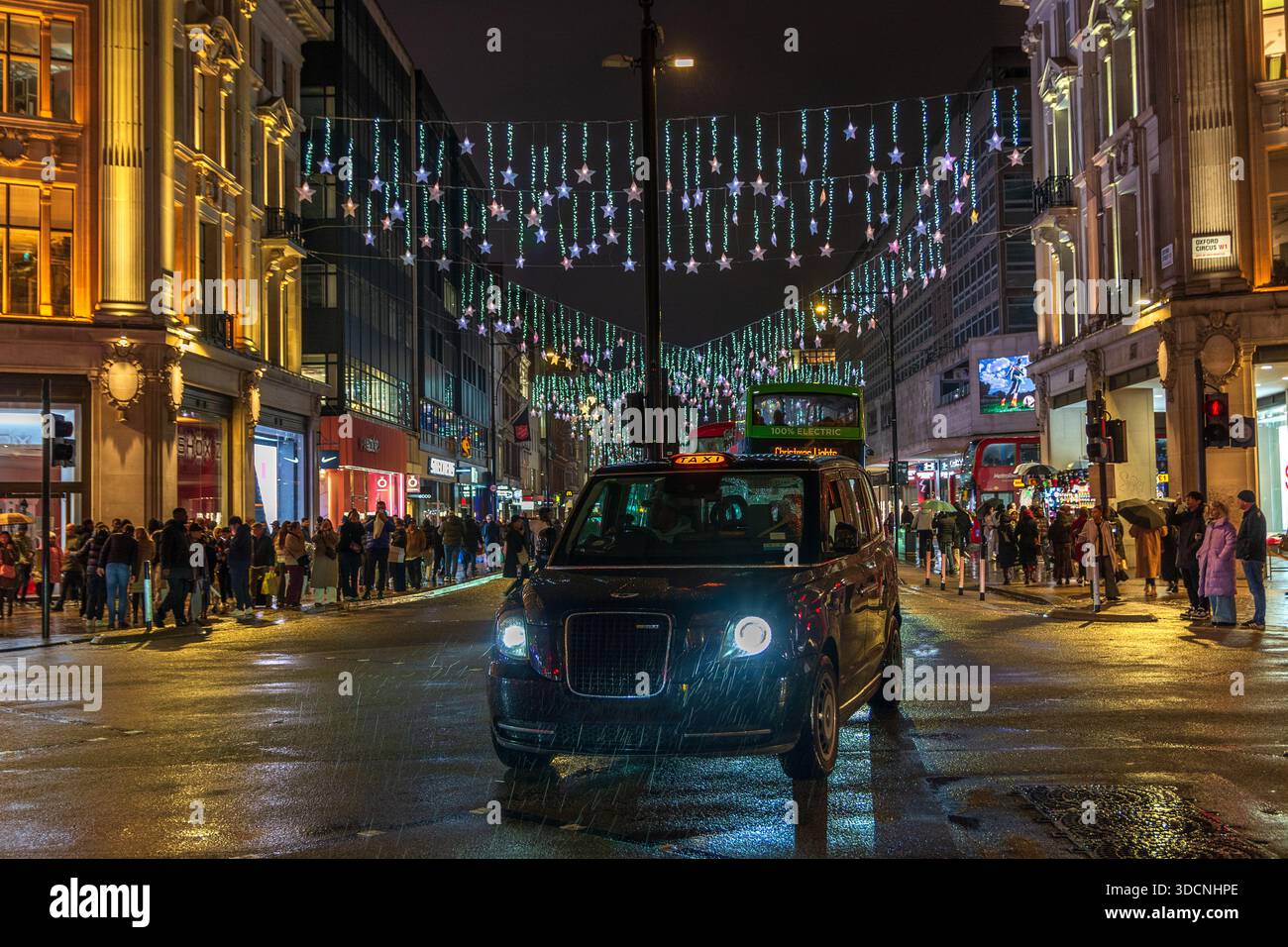 Oxford Circus Christmas Lights, London taxi in the December rain, Oxford Street, Londra, Inghilterra, Regno Unito. Inverno. Scena notturna. Foto Stock