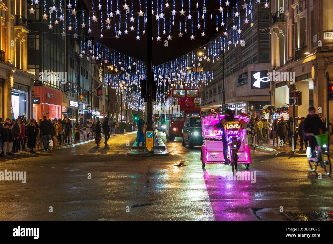Decorazioni natalizie, Oxford Street, Londra, Inghilterra, Regno Unito. Inverno. Scena notturna. Foto Stock