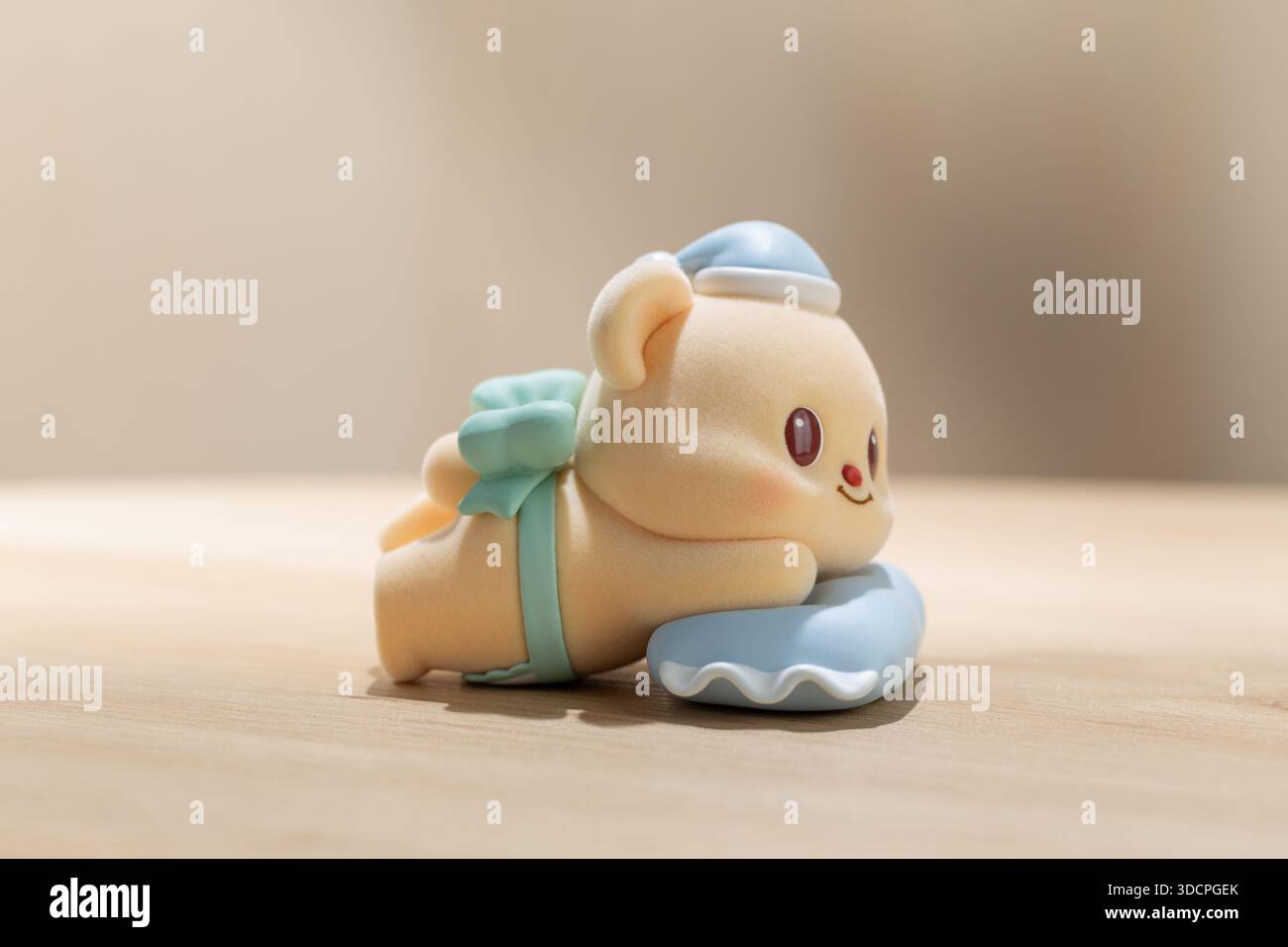 BangkokThailand - 24 dicembre 2025: Il giocattolo ButterBear si rilassa su un morbido cuscino blu, evidenziando il design carino del personaggio, l'umore calmo e il colon Foto Stock