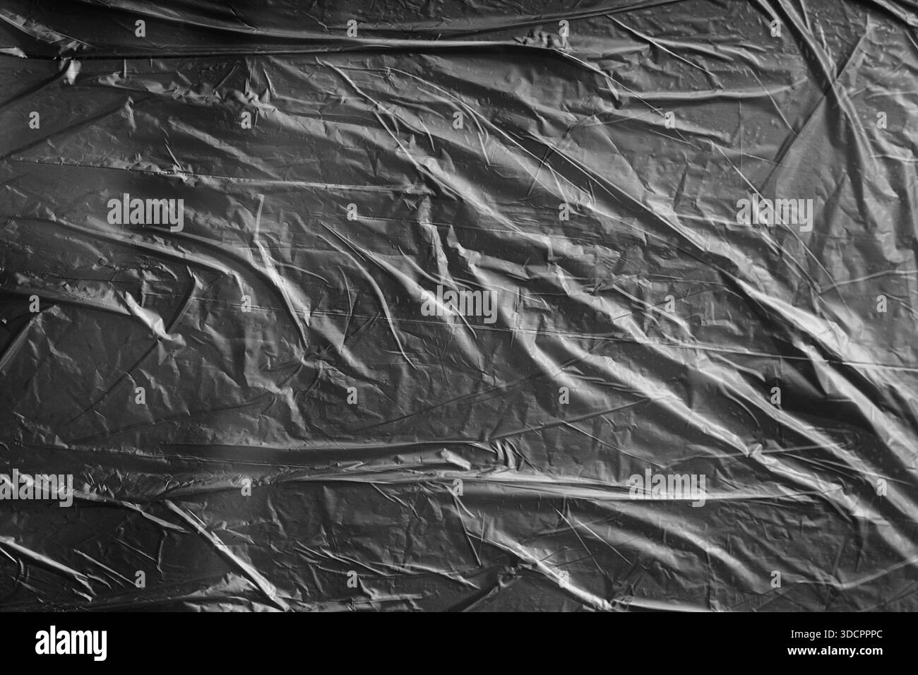 Superficie in plastica increspata nera, texture industriale grintosa per design urbano, grunge o packaging. Foto Stock
