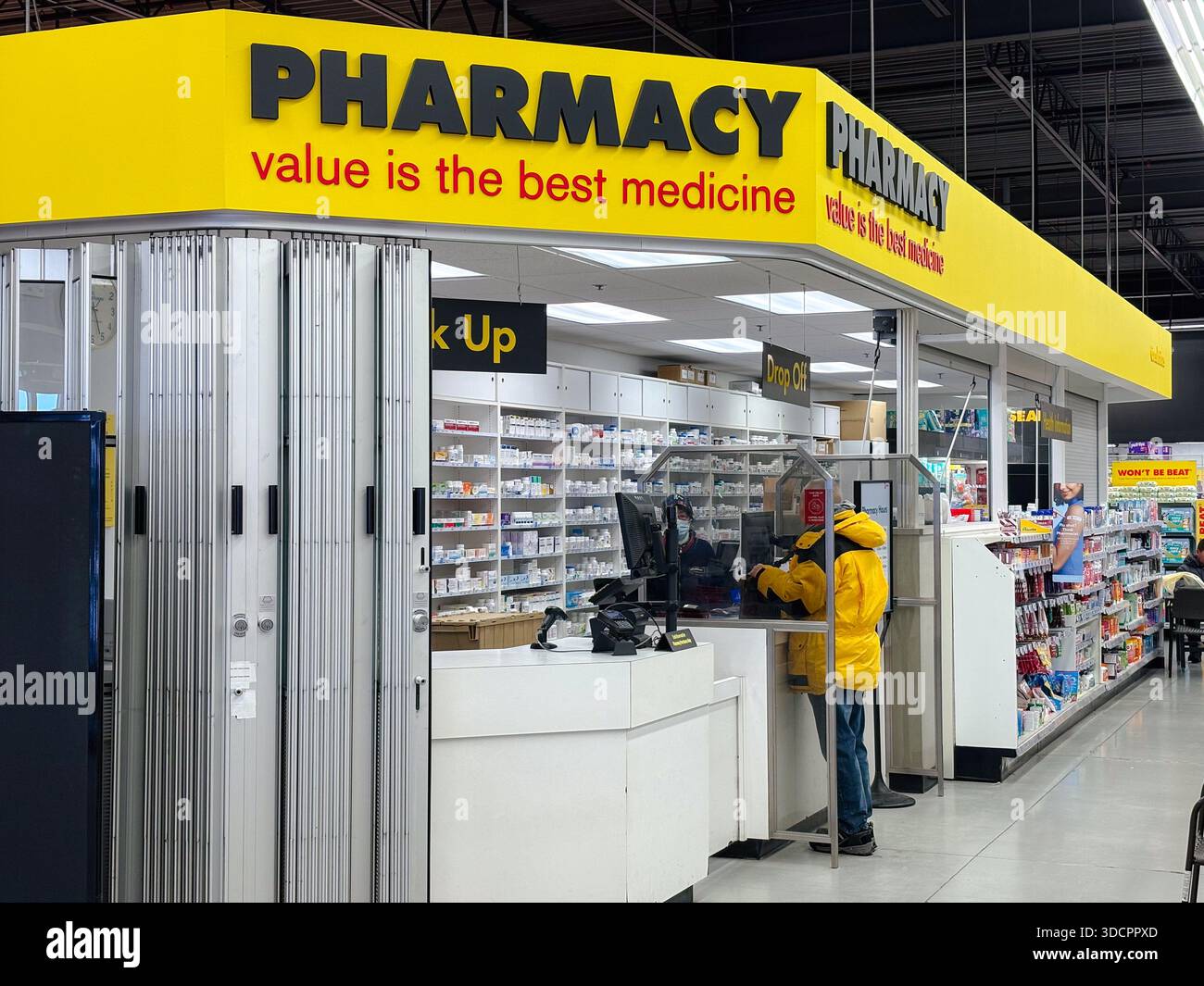 Niente farmacia Frills. Farmacia, farmacista. Cliente presso un banco di prescrizione in un negozio di alimentari con farmaci sugli scaffali. Foto Stock