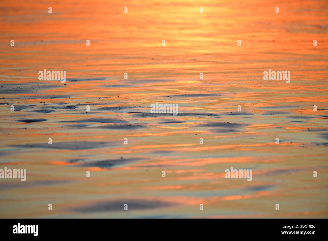 Tramonto sulla costa atlantica. Riflessi nell'acqua in tonalità pastello. Foto Stock