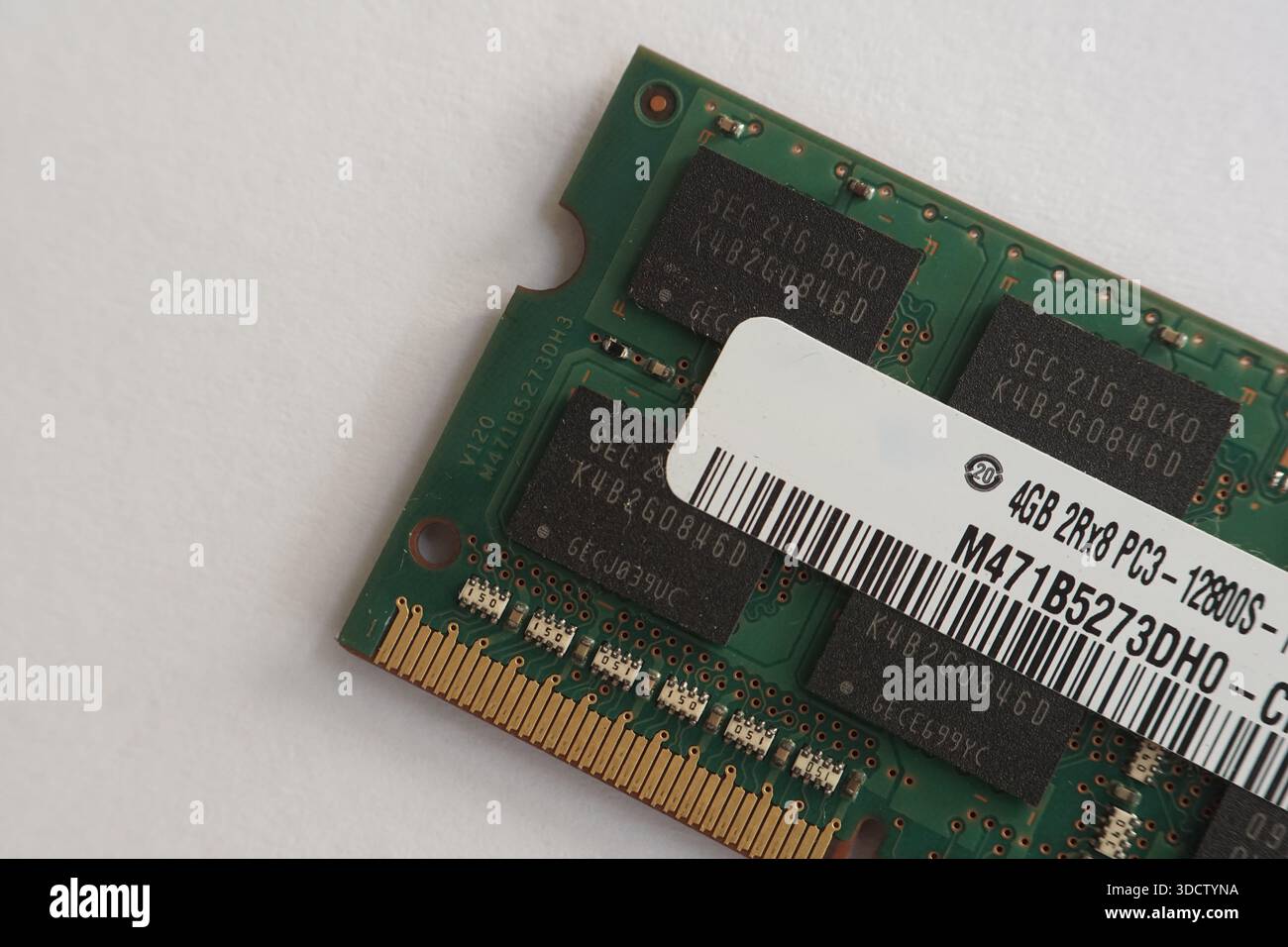 Immagine dettagliata dell'angolo di un modulo RAM, che mostra i chip di memoria "V120" e il bordo dell'etichetta delle specifiche. Foto Stock