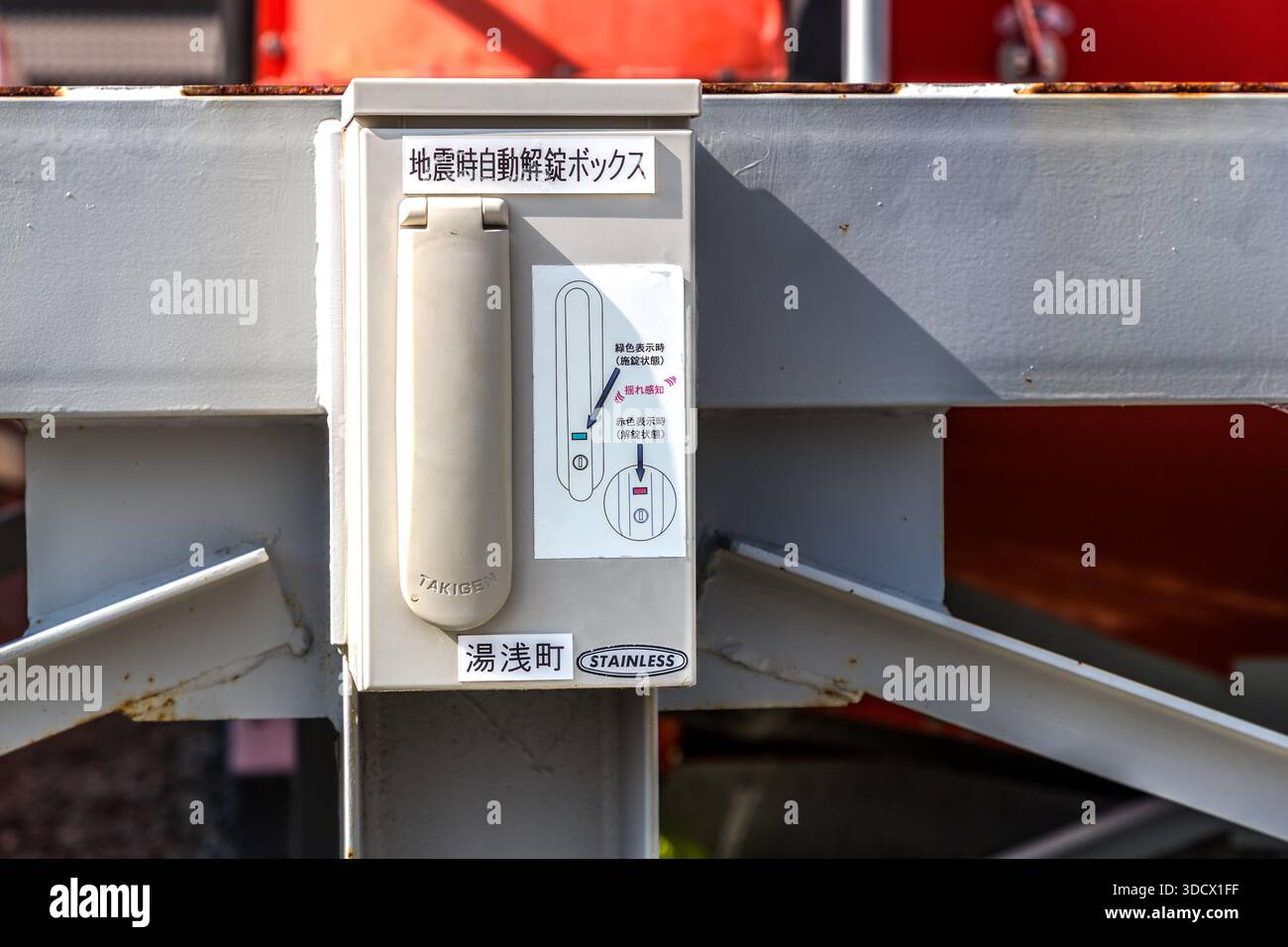 Una scatola di sblocco automatico in caso di terremoto è appesa al telaio di supporto della capsula di salvataggio TTS-005 a Yuasa, prefettura di Wakayama, Giappone, etichettata "地震時自動解錠ボックス" (scatola di sblocco automatico in caso di terremoto) e il nome del luogo "湯浅町" (Città di Yuasa). Il meccanismo rilascia automaticamente la serratura di accesso della capsula di salvataggio per tsunami durante un forte terremoto. Foto Stock