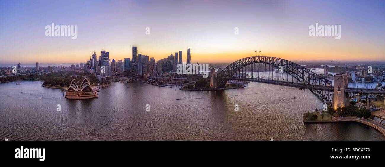 Luce del tramonto dietro il lungomare del CBD di Sydney attraverso il porto dal ponte di Kirribilli con vista aerea della città. Foto Stock