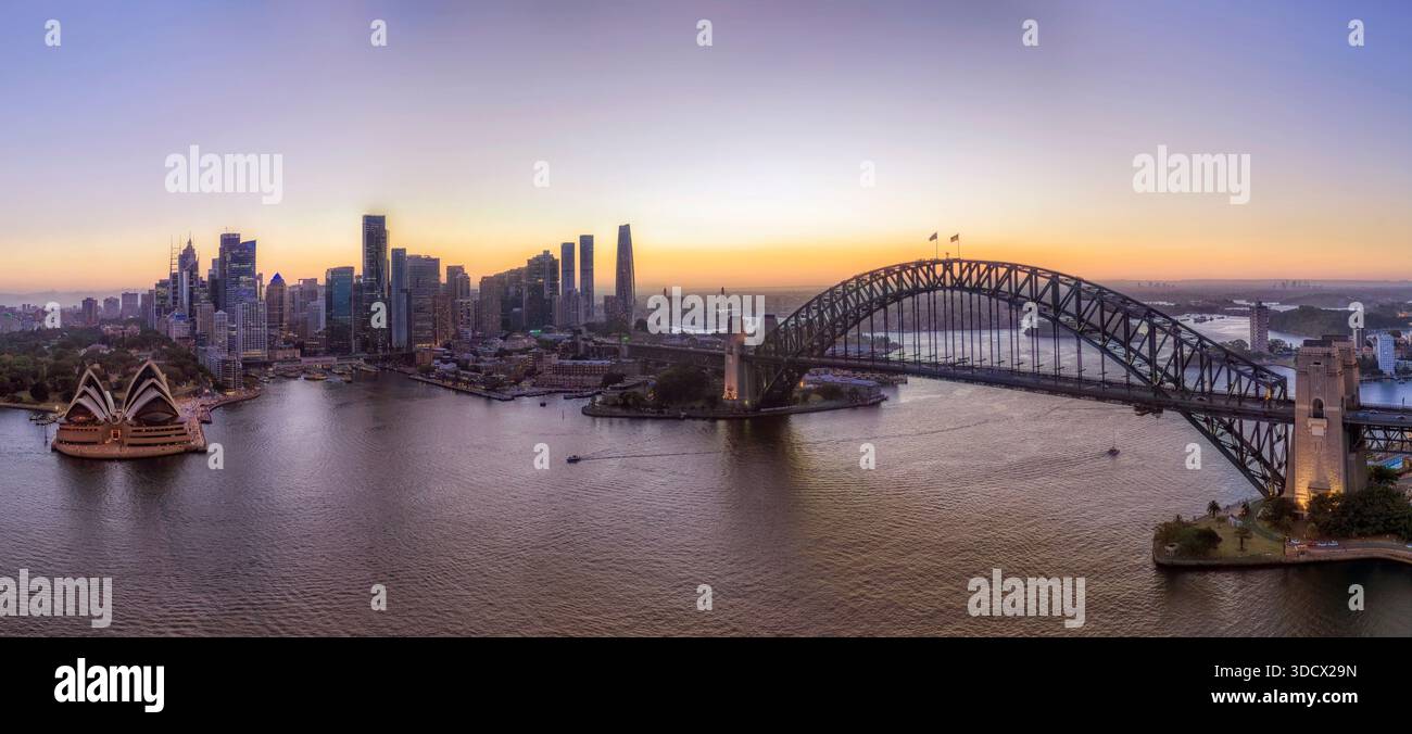 Luce del tramonto dietro il lungomare del CBD della città di Sydney attraverso il porto vicino al ponte da Kirribilli, con vista panoramica aerea della città. Foto Stock