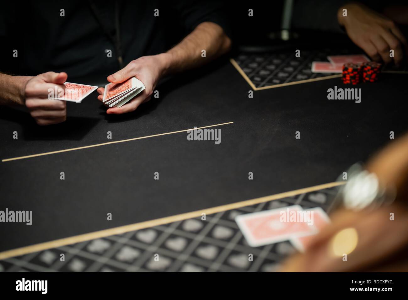 Il mazziere di casinò gestisce il mazzo di carte sulla superficie del tavolo da gioco, illustrando la tecnica professionale di negoziazione e gli standard operativi nel gioco d'azzardo Foto Stock