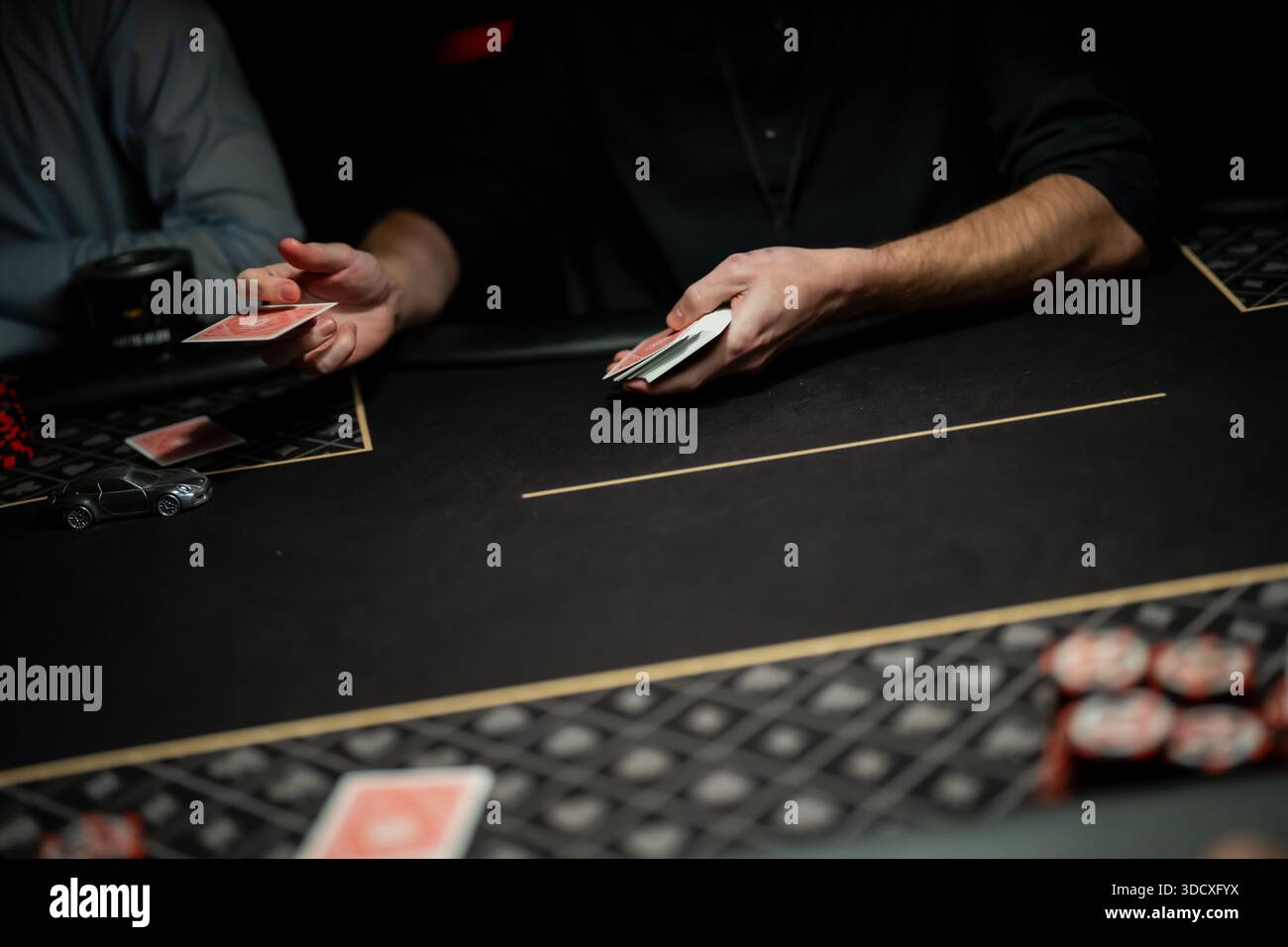 Il mazziere di casinò che rilascia una singola carta da gioco a mezz'aria verso l'area di scommessa, catturando il movimento preciso della carta e le pratiche di negoziazione regolamentate in diretta Foto Stock
