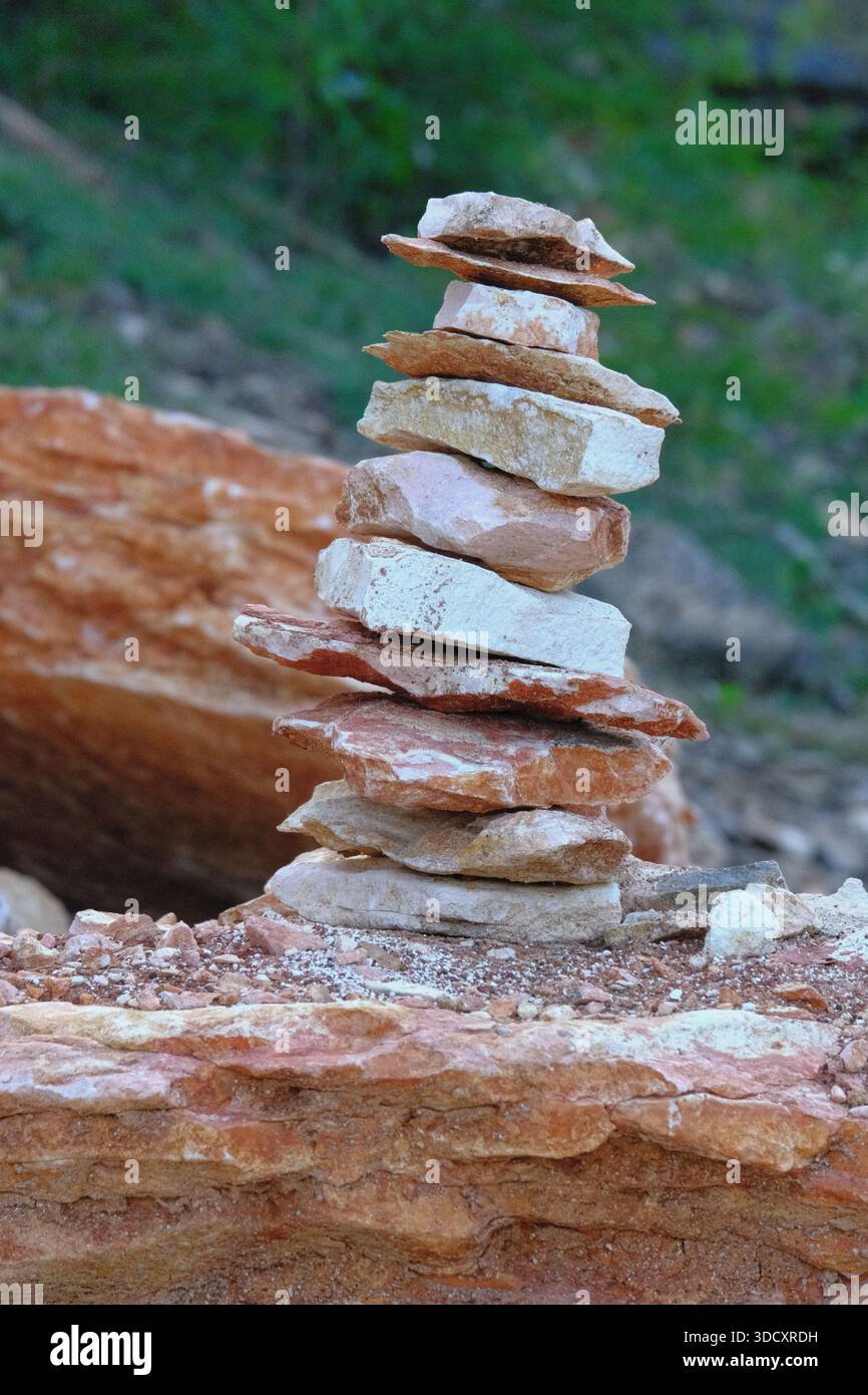 Formazione di roccia piana naturale impilata l'una sull'altra formando un cairn. Le rocce mostrano tonalità alternate di marrone-rossastro e bianco pallido. Foto Stock