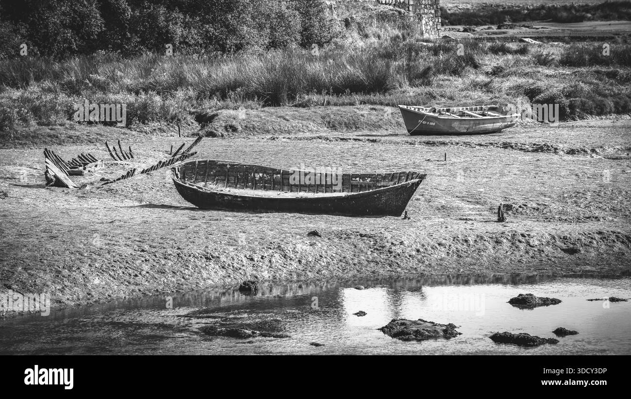 Tre barche abbandonate sulla riva del Ria de Barro, dark mood, effetto grafico, bianco e nero, monocromatico, 16:9 Foto Stock