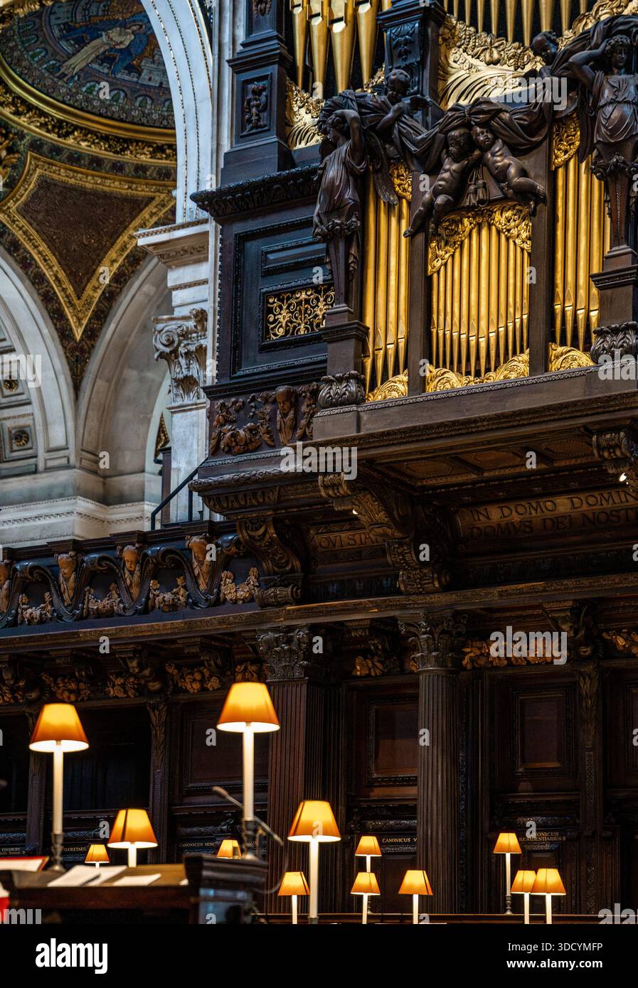 L'organo sopra la Quire, dove il coro e il clero siedono durante le funzioni, con lampade calde e bancarelle intagliate, nella Cattedrale di St Paul, Londra, Regno Unito Foto Stock