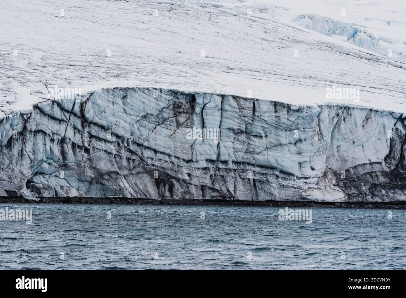 Scogliera di ghiaccio di un ghiacciaio costiero che incontra il mare lungo la costa antartica. Foto Stock
