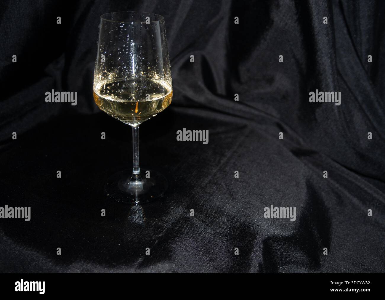 Un bicchiere di vino bianco fresco e freddo è stato versato in modo sciocco, ma comunque meraviglioso Foto Stock