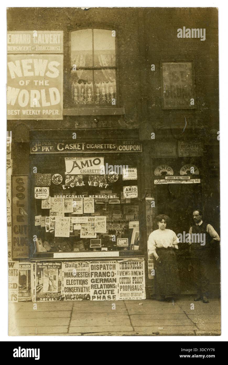 pc di coppia dell'era della prima Guerra Mondiale fuori Calverts Tobacconist & newsagent shop, tabelloni della prima Guerra Mondiale, Manchester. Circa 1914 o 1915 relazioni franco-tedesche fase acuta sul cartellone. Foto Stock