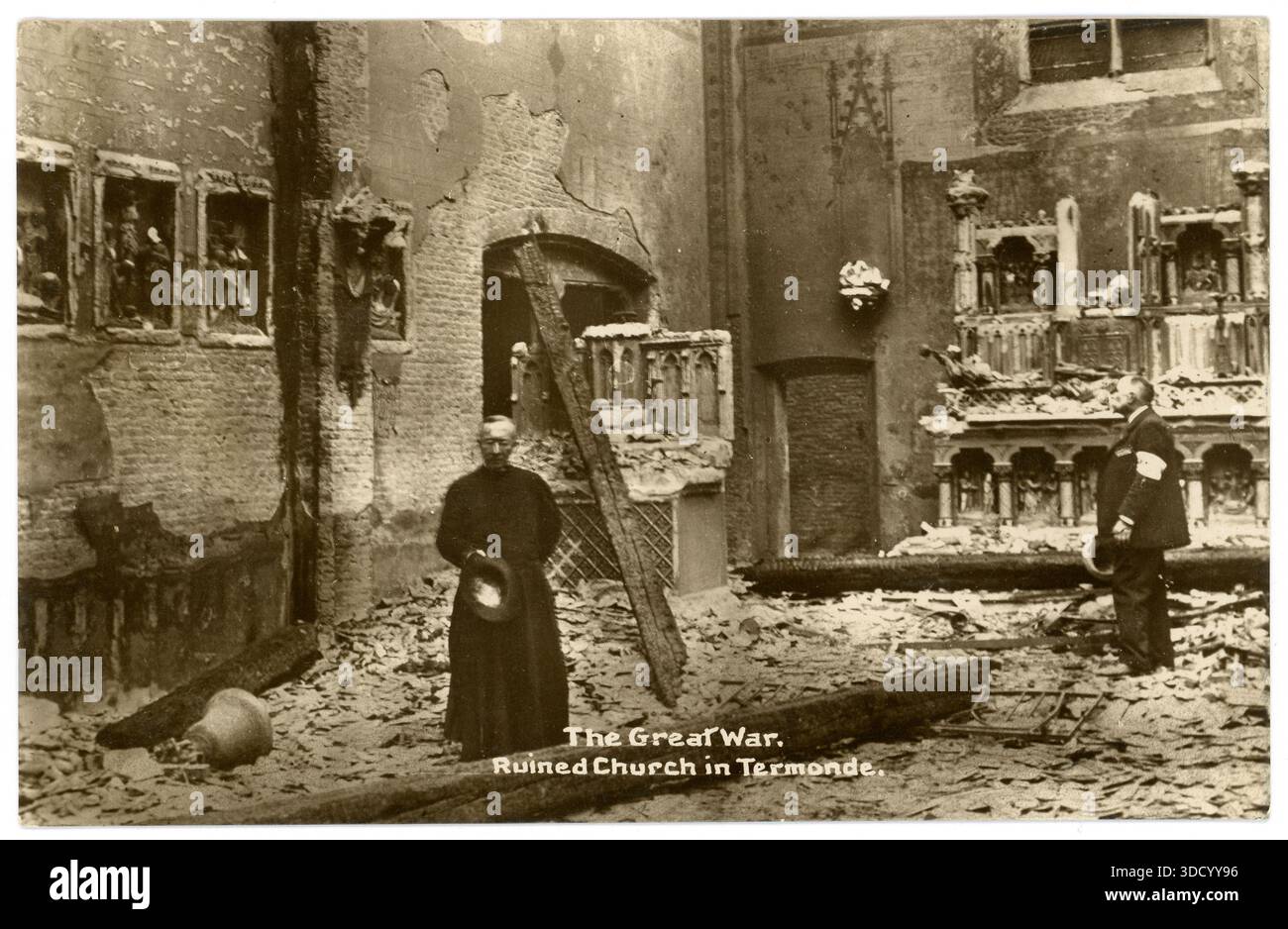 Cartolina originale dell'epoca della prima guerra mondiale di un ecclesiastico in piedi tra l'interno bombardato della chiesa di San Martino a Termonde (Dendermonde), in Belgio, a seguito degli attacchi tedeschi nel settembre 1914 durante la prima guerra mondiale. Foto Stock