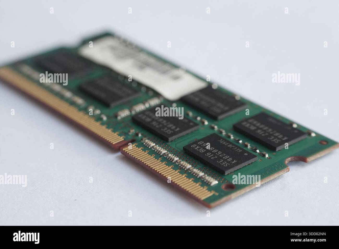 Macro shot che enfatizza il bordo della RAM stick e i suoi contatti dorati. Rappresenta il punto di collegamento vitale per il trasferimento dei dati nei sistemi informatici. Foto Stock