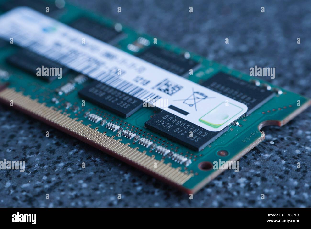 Primo piano di una memory stick DDR3 appoggiata su una superficie scura e macchiata simile a una pietra. Offre un contrasto high-tech tra materie prime ed elettr. Raffinate Foto Stock