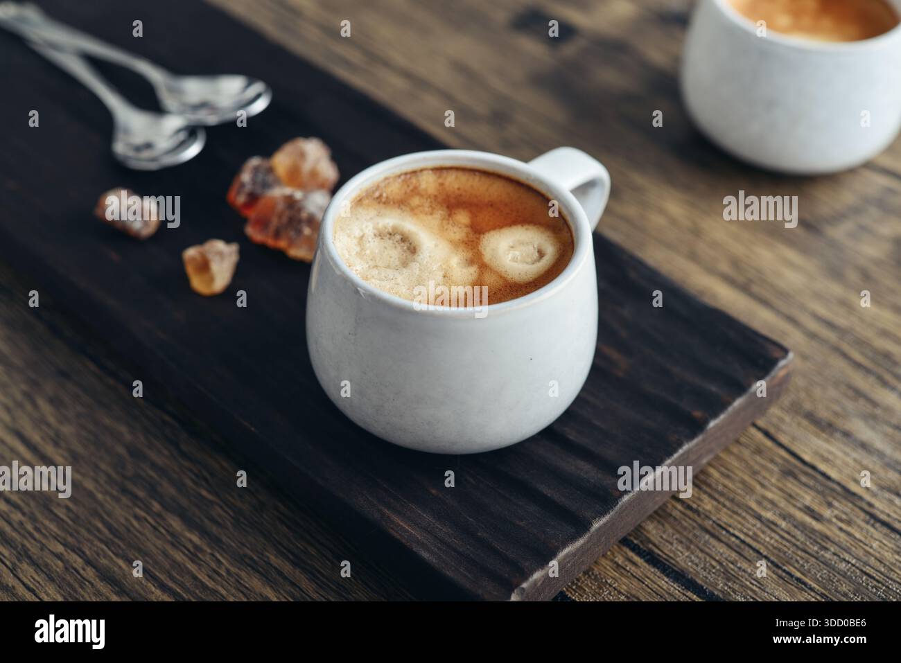 Due tazze di caffè su vassoio di legno con primo piano di zucchero di canna Foto Stock