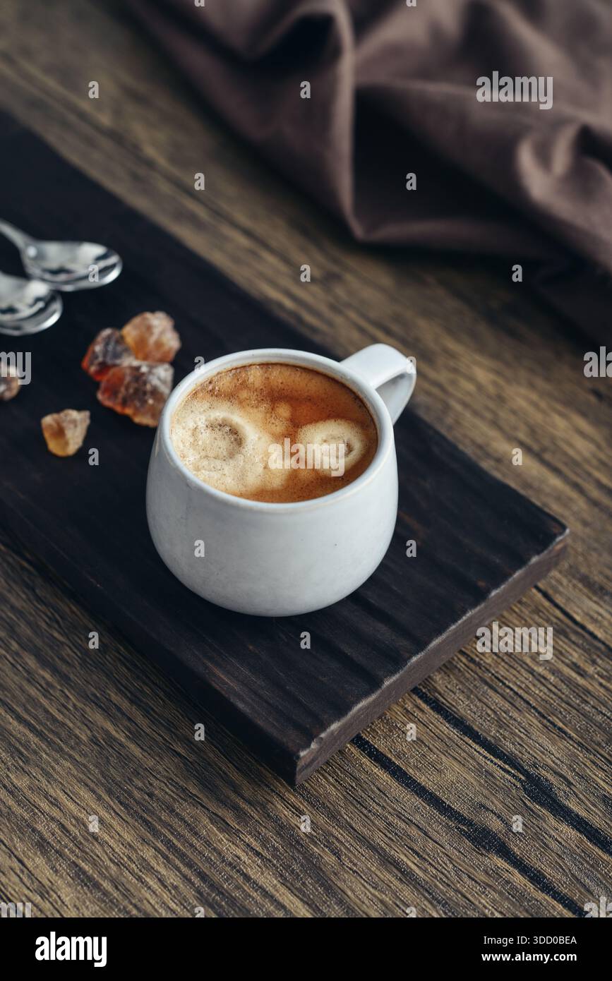 Due tazze di caffè su vassoio di legno con primo piano di zucchero di canna Foto Stock
