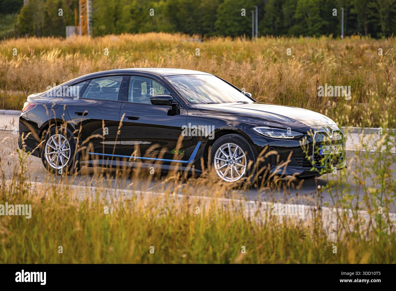 Auto nera sul lato della strada circondata da campi e alberi, auto elettrica BMW i7, Deer e- Carsharing, Calw, Germania Foto Stock