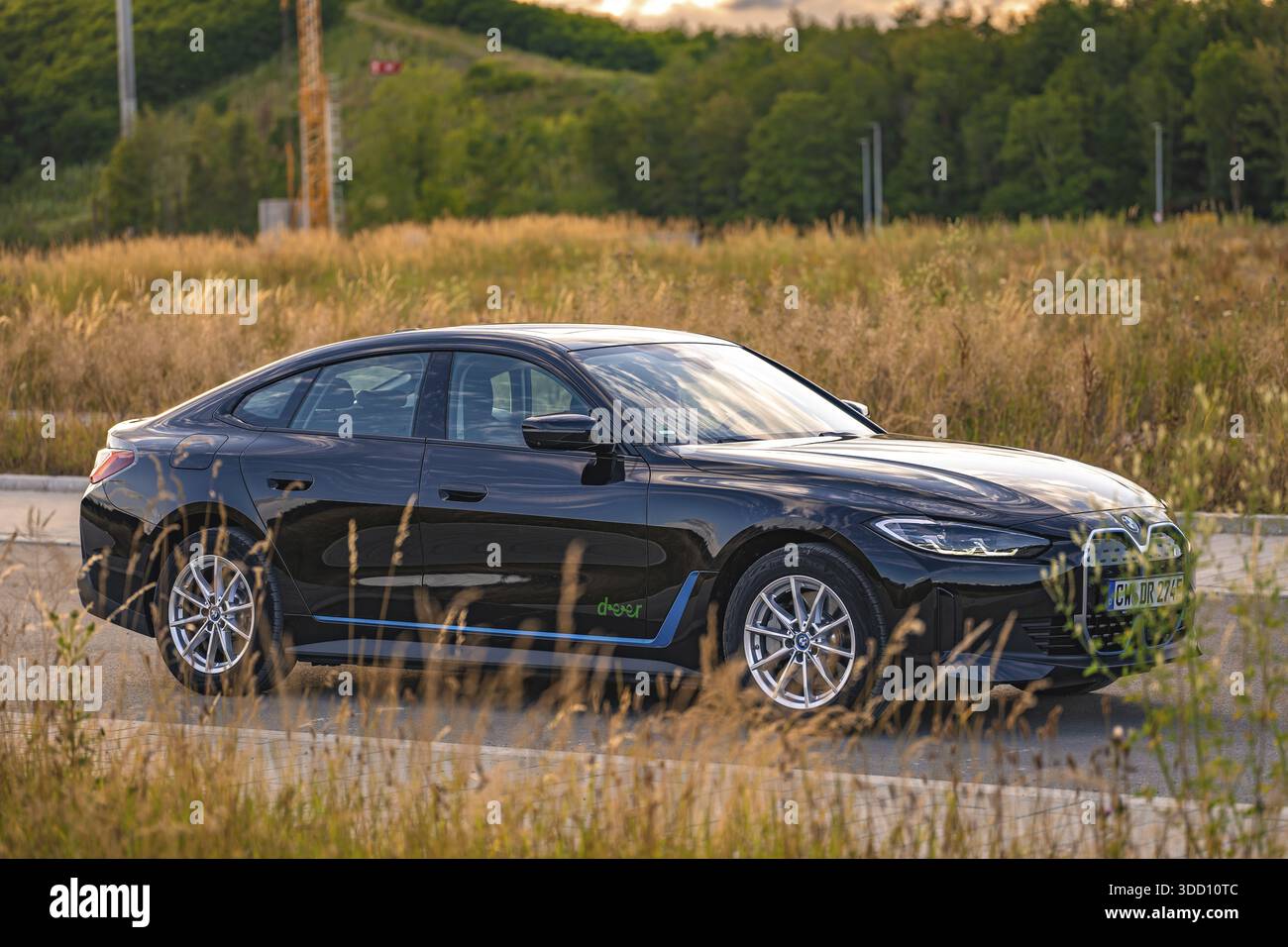 Auto nera in un campo con ambiente naturale e disposizione stradale, auto elettrica BMW i7, Deer e-Carsharing, Calw, Germania Foto Stock