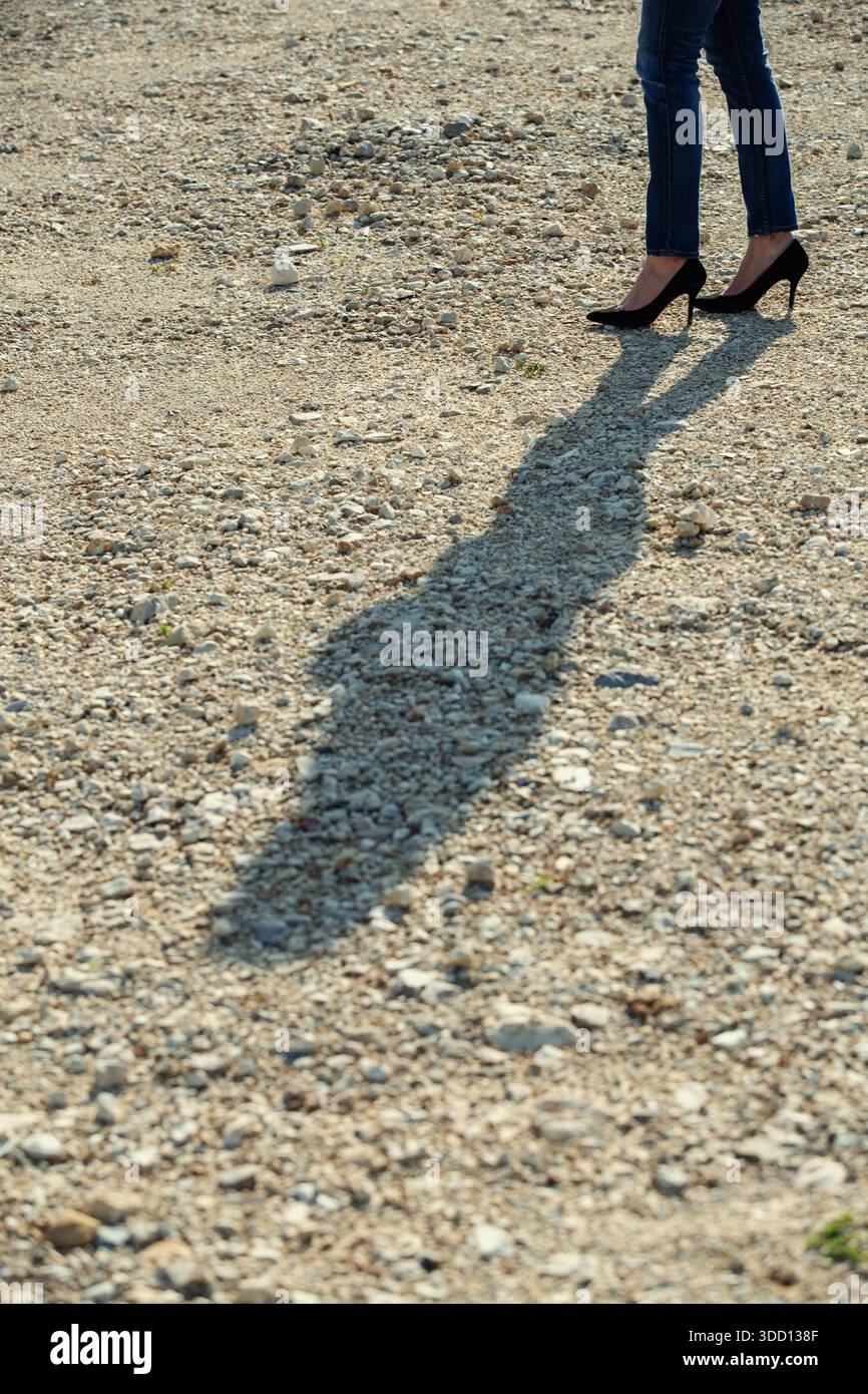 L'ombra della donna sulla strada sterrata Foto Stock
