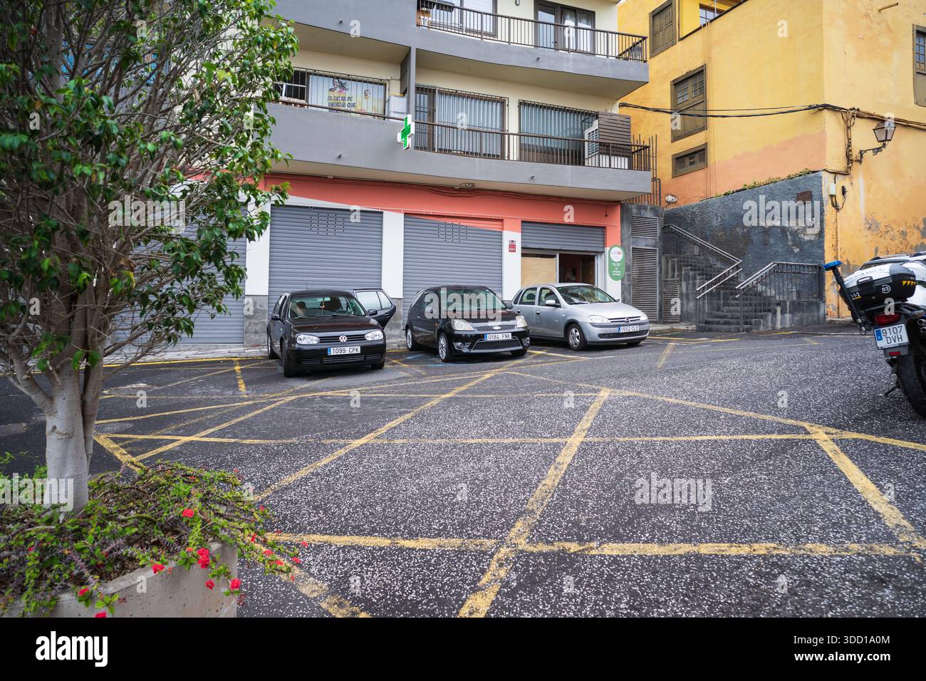 Parcheggio in strada con auto compatte e motociclette vicino all'edificio residenziale. Tenerife, Isole Canarie, Spagna. Foto Stock