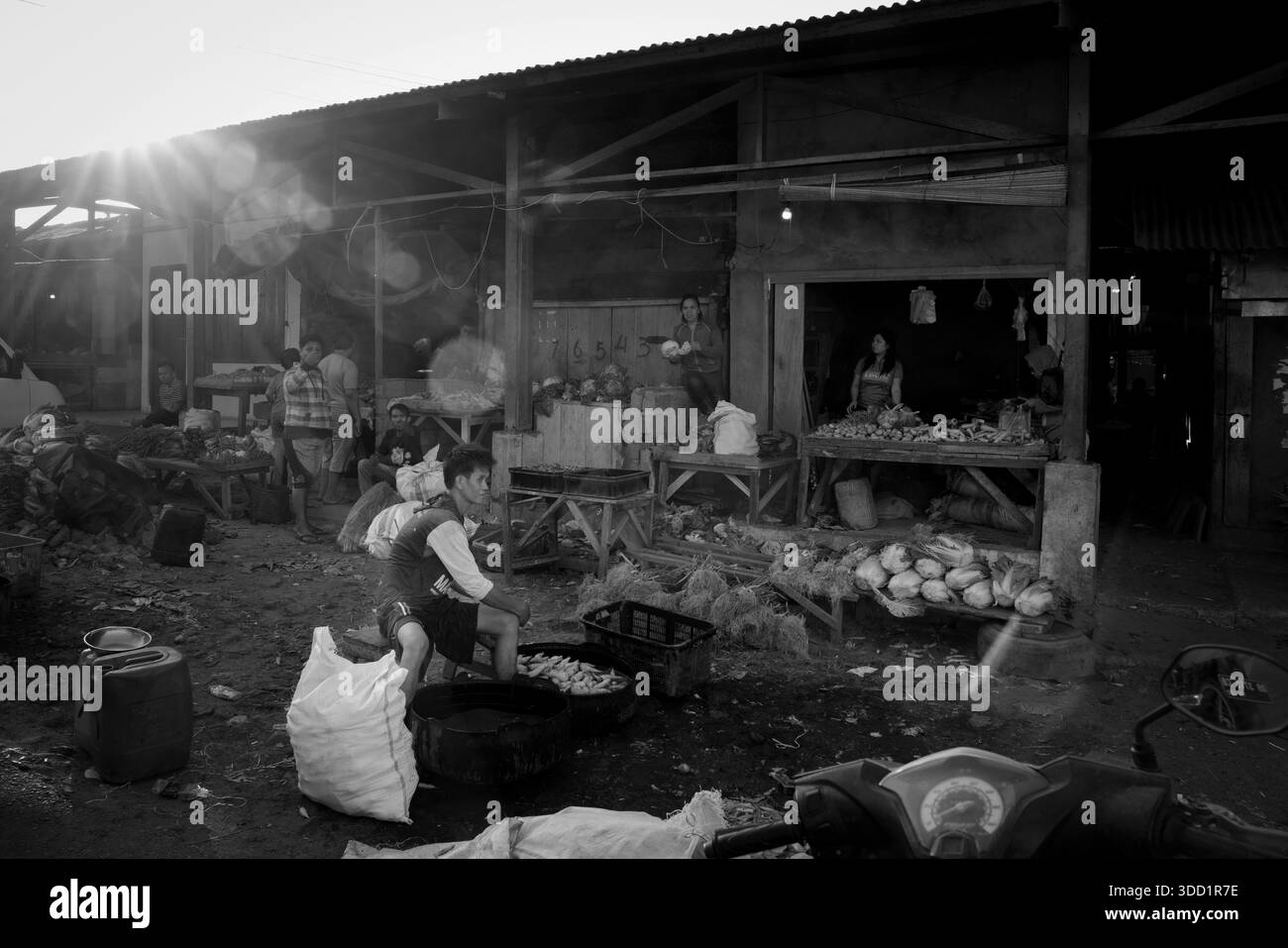 Scena in bianco e nero di gente del posto che lavora e vende merci in un mercato tradizionale del mattino Foto Stock