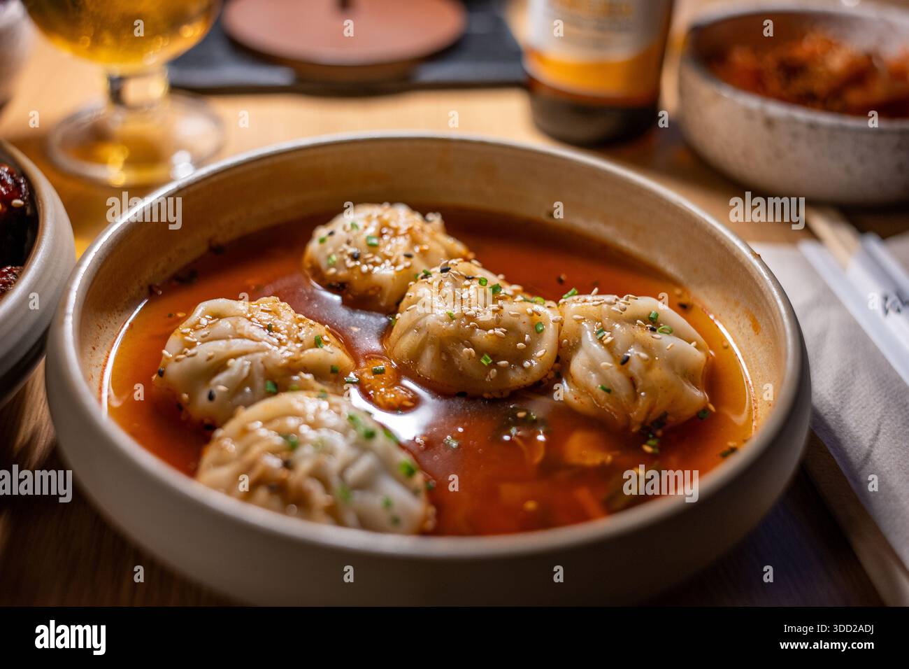 Primo piano di gnocchi Mandu in salsa Buldak calda servita in un ristorante coreano Foto Stock