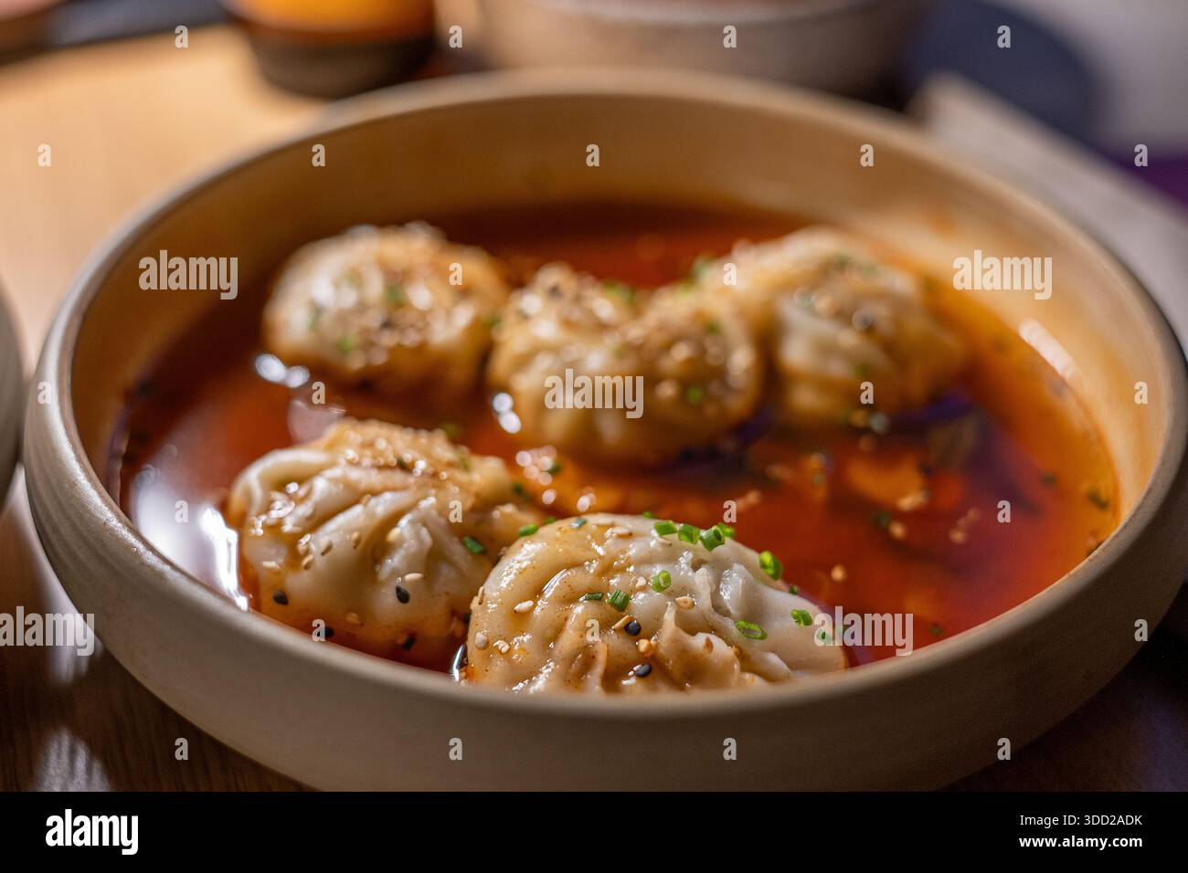 Primo piano di gnocchi Mandu in salsa Buldak calda servita in un ristorante coreano Foto Stock