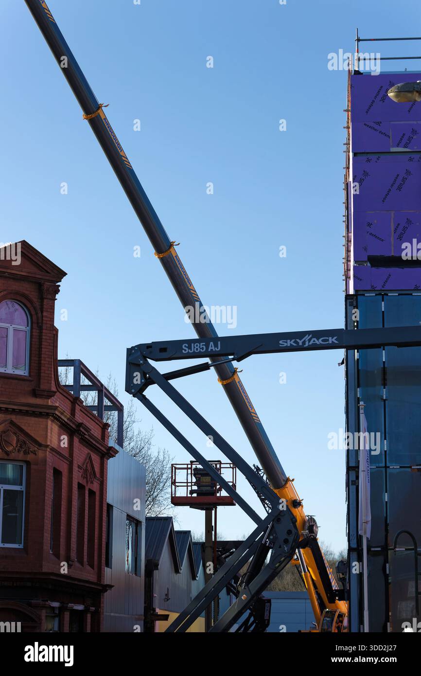 Apparecchiature di accesso aereo sul cantiere del centro civico radcliffe con l'edificio delle camere del mercato a Greater manchester nel regno unito Foto Stock