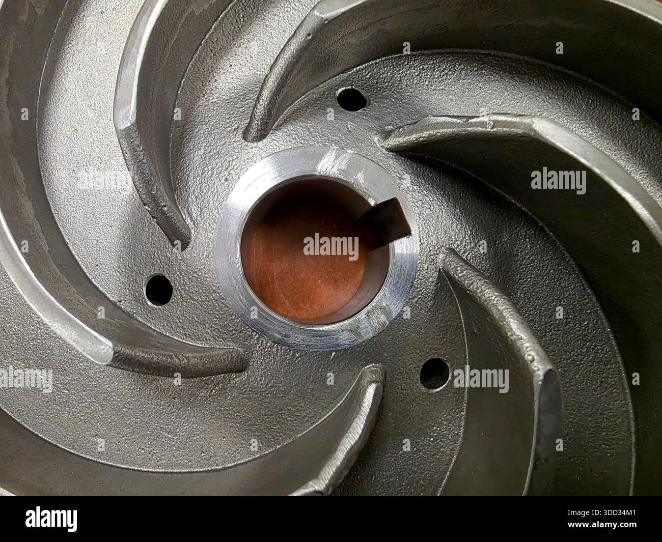 Una girante della pompa in acciaio inox mostra la sua struttura interna e le sue caratteristiche. L'attenzione è concentrata sulle alette e sull'apertura centrale senza ulteriori operazioni Foto Stock