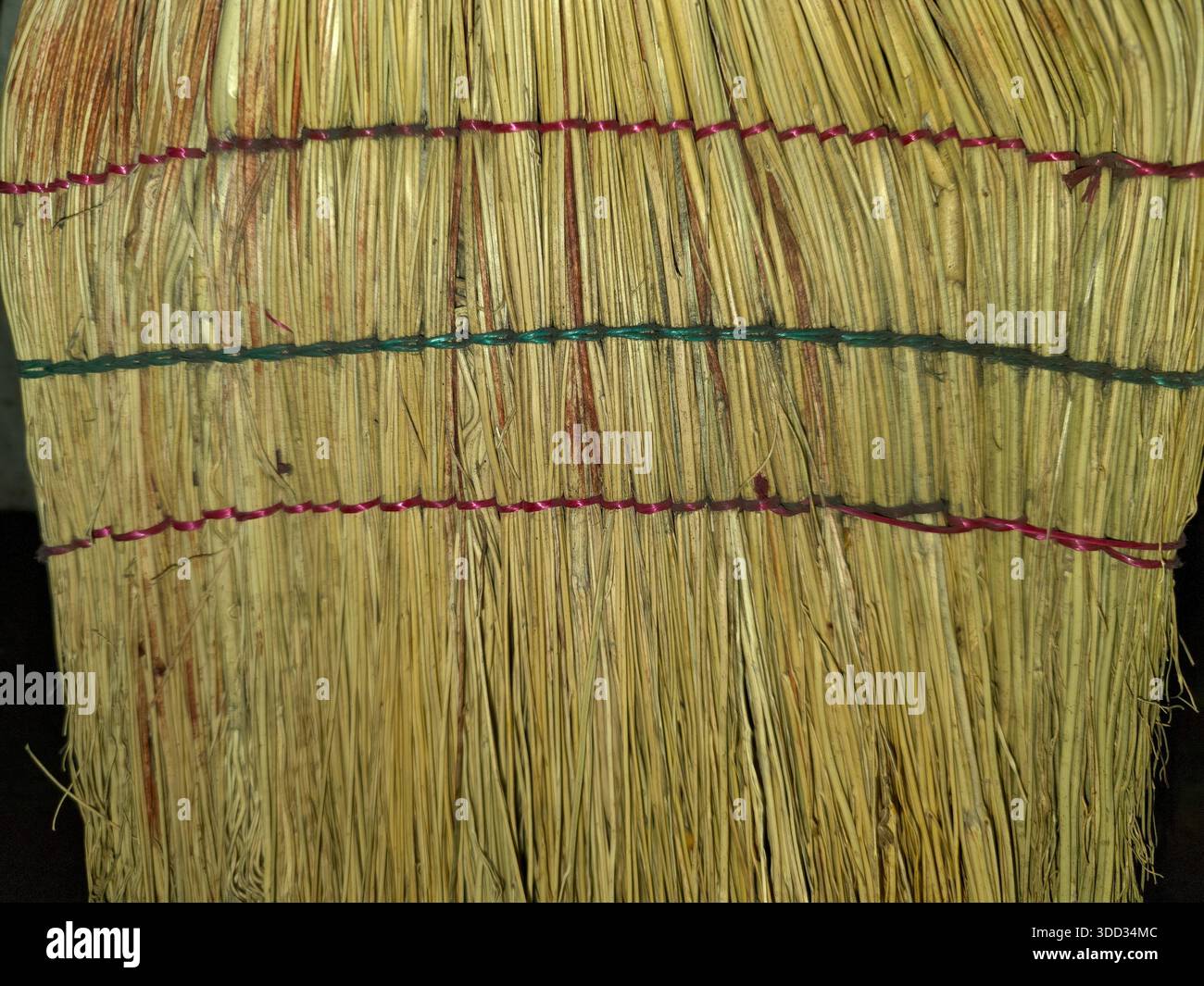 Il sorgo della scopa viene raggruppato insieme per creare spazzatrici. Questo processo mostra materiali naturali utilizzati nelle comunità rurali per i TAS pratici Foto Stock