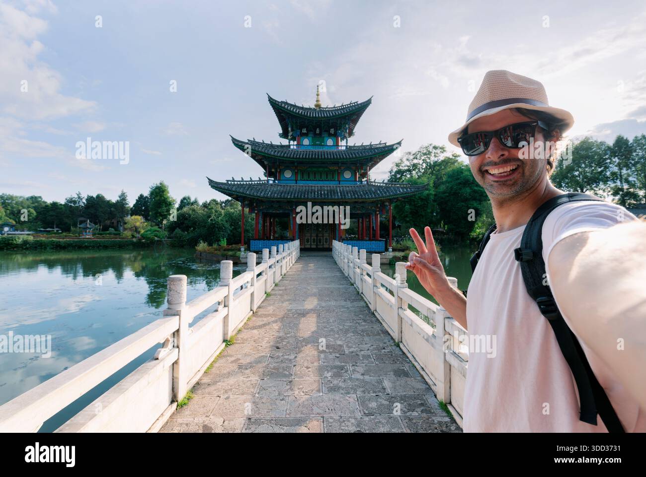 Un ragazzo fa un selfie in un tempio in stile cinese. Un adolescente europeo in viaggio in Cina. Foto Stock
