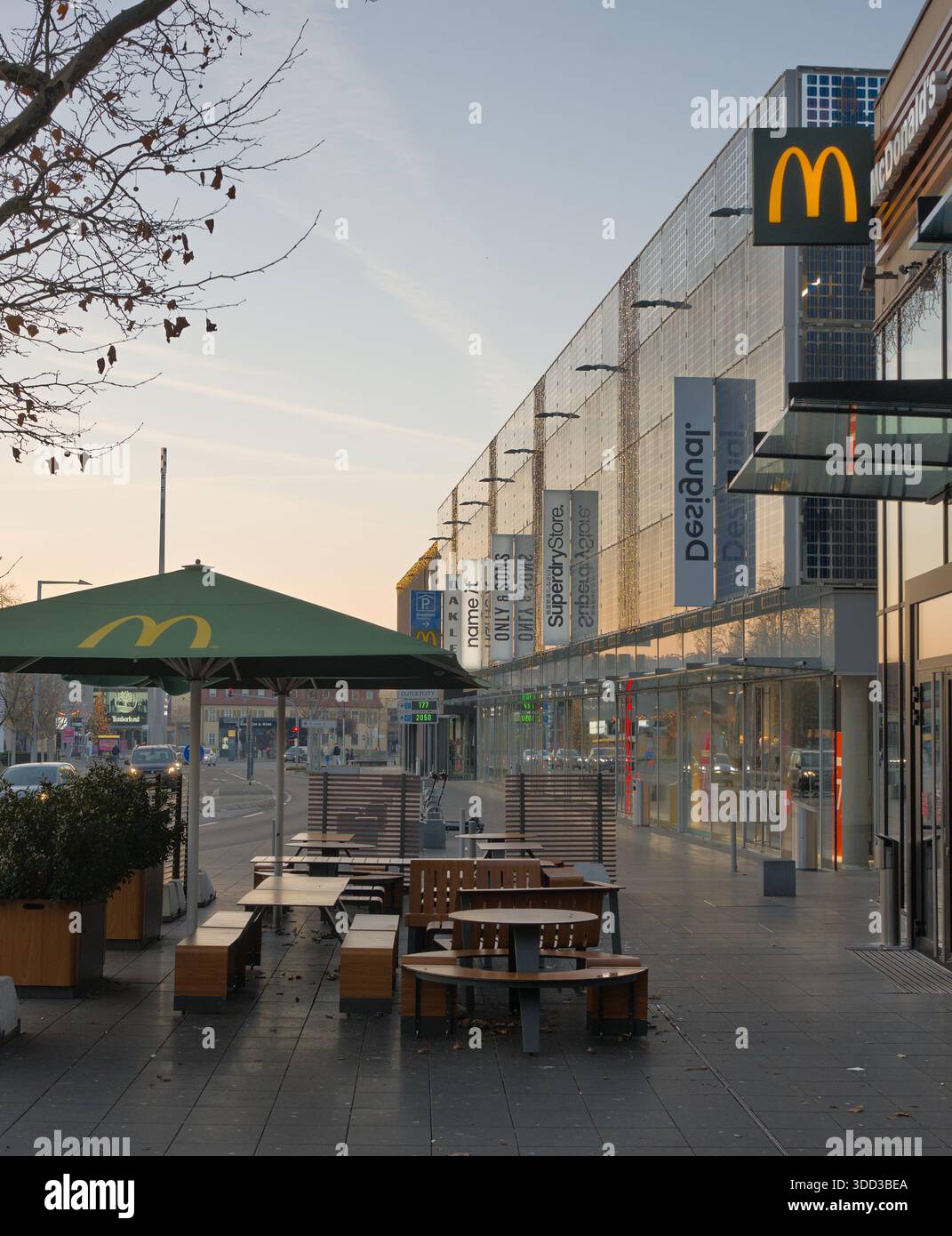 Vista sulla strada di un ristorante fast food con posti a sedere all'aperto lungo una vivace via dello shopping in un ambiente urbano. Outletcity Metzingen Foto Stock