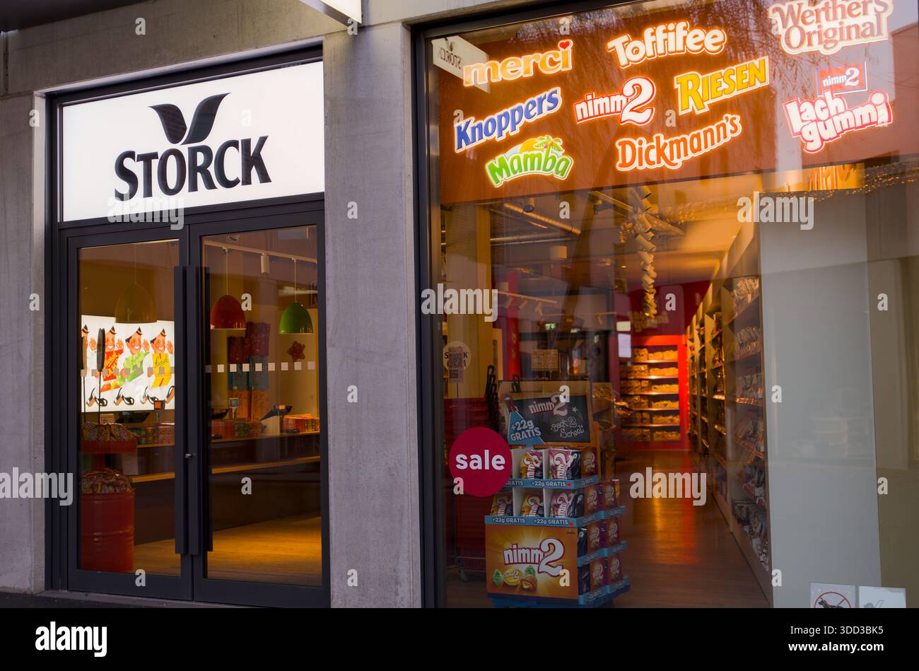 Negozio di caramelle con aree d'ingresso illuminate, cartellonistica colorata e un'atmosfera invitante in un outlet per lo shopping. Periferia di Metzingen Foto Stock