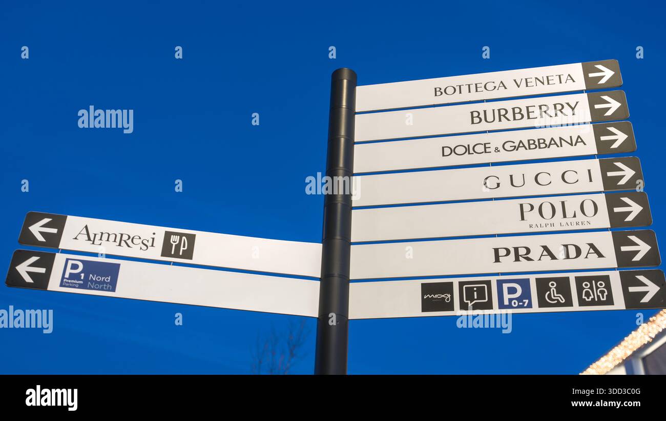 Cartellone con diversi loghi di lusso su un cielo azzurro in un moderno complesso commerciale. Outletcity Metzingen Foto Stock