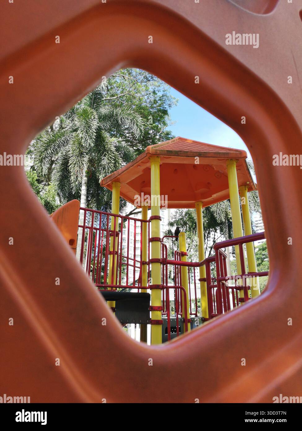 Colorato parco giochi urbano visto attraverso una cornice geometrica astratta che simboleggia l'infanzia, la sicurezza, gli spazi della comunità e la vita moderna della città. Foto Stock
