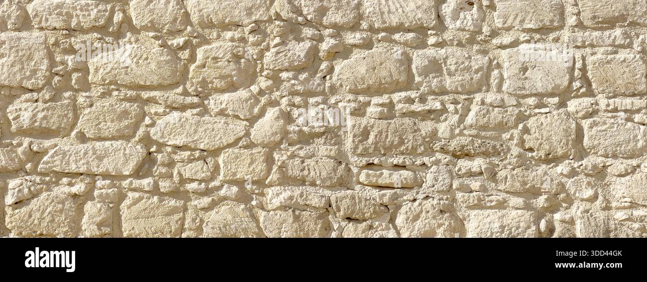 Parete in pietra che mostra dettagli di muratura rustica e rustica e consistenza di roccia naturale Foto Stock