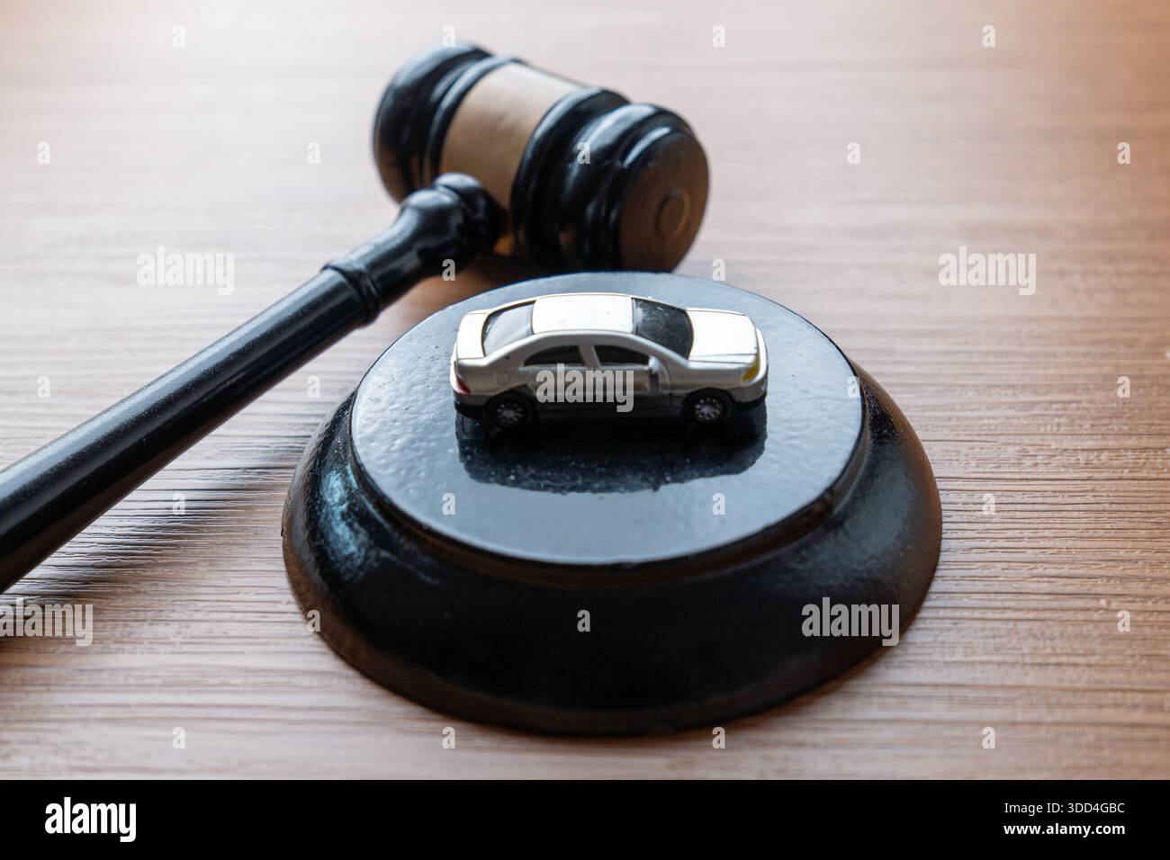 Un martelletto giudice e un'auto in miniatura su un tavolo di legno. Asta di automobili, legge sui veicoli, reclami assicurativi, norme sulla circolazione. Foto Stock