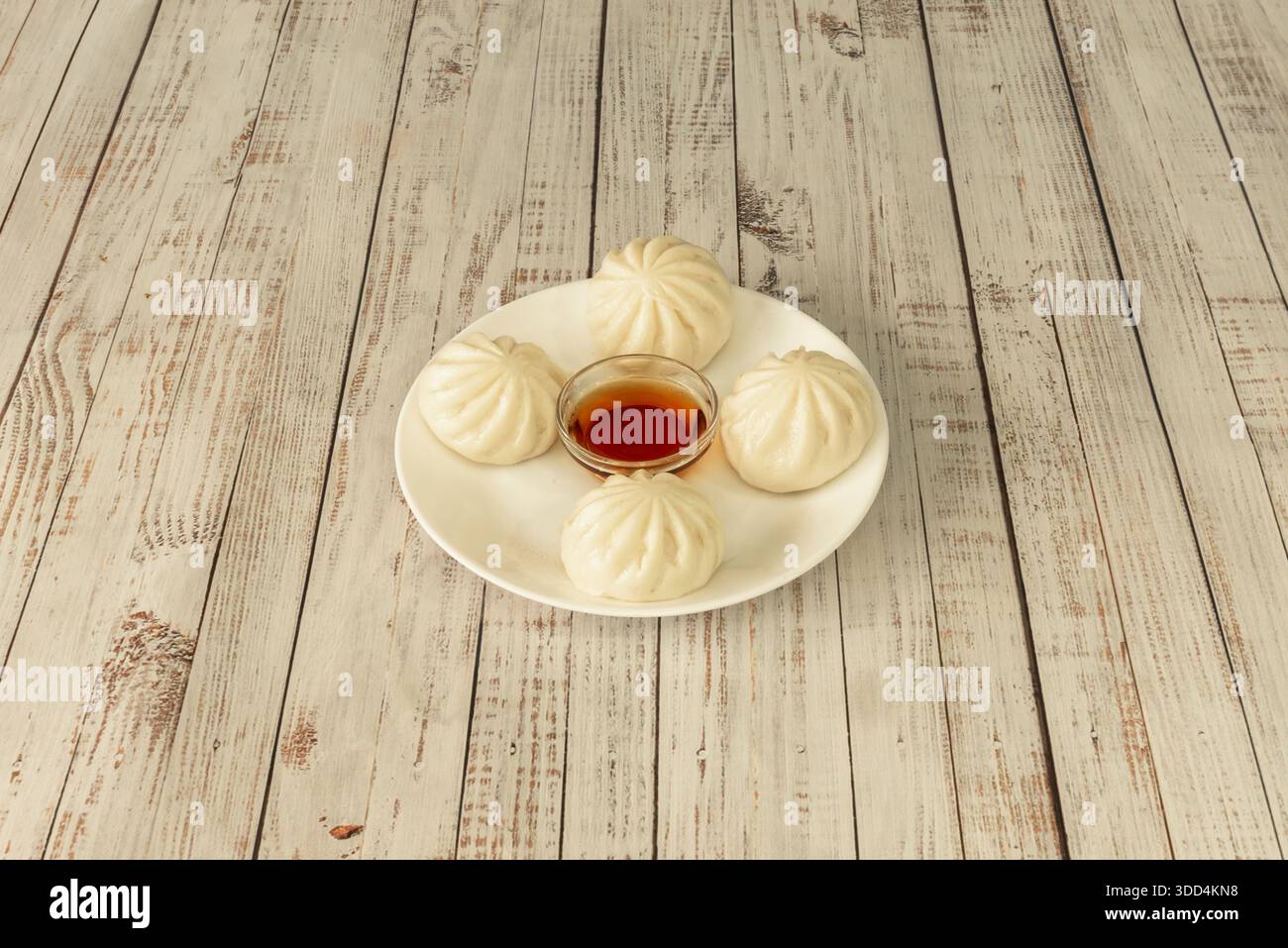 Xiaolongbao dim sum con la loro caratteristica pelle sottile e traslucida, ripiena di brodo succoso e di maiale, presentata nel loro tradizionale vaporizzatore di bambù Foto Stock