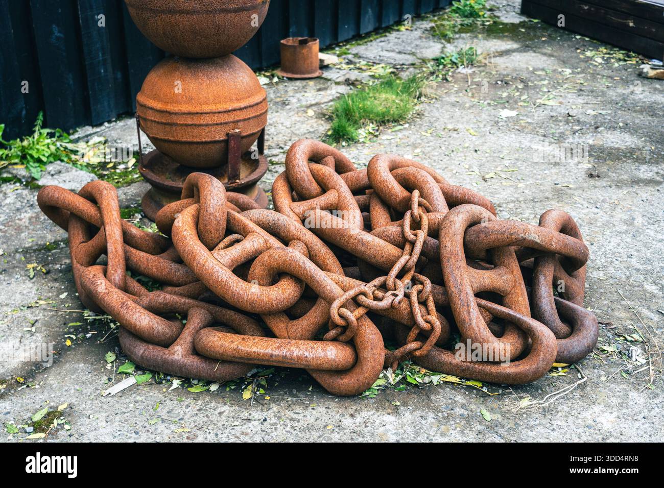 Grande catena arrugginita. Enorme catena navale in un porto, strumenti abbandonati, rovinati dal maltempo. Foto Stock