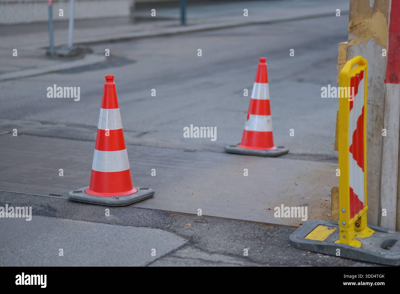 Coni stradali e barriere di sicurezza che segnalano la zona di costruzione stradale su una strada cittadina. Infrastrutture urbane, lavori di riparazione, sicurezza dei trasporti, avvertenza c Foto Stock