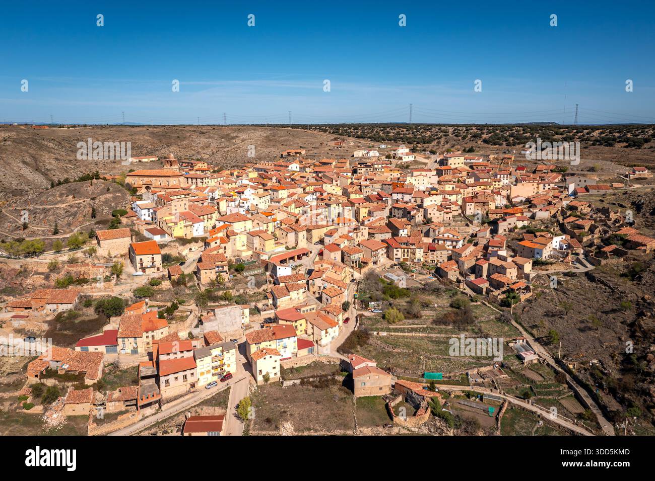 Veduta aerea di Un villaggio sul tetto di terracotta situato tra colline aride e pianure aperte, Ejulve, Teruel, Spagna Foto Stock