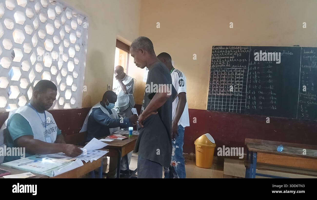 (251229) -- CONAKRY, 29 dicembre 2025 (Xinhua) -- Un membro del personale assiste un elettore nella verifica delle informazioni presso un seggio elettorale a Conakry, capitale della Guinea, il 28 dicembre 2025. La Guinea ha iniziato a votare nelle sue elezioni presidenziali domenica, con più di 6,8 milioni di elettori registrati che dovrebbero votare in oltre 24.000 seggi nazionali tra le 7:00 (ora locale 0700 GMT) e le 18:00 (1800 GMT). Si tratta delle prime elezioni presidenziali del paese da quando un colpo di Stato militare ha rovesciato l'ex presidente Alpha Conde nel settembre 2021, segnando un passo importante verso il ret Foto Stock