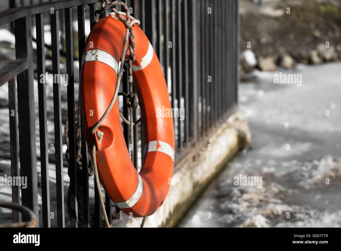 Primo piano con il salvagente arancione sullo sfondo di un lago ghiacciato Foto Stock