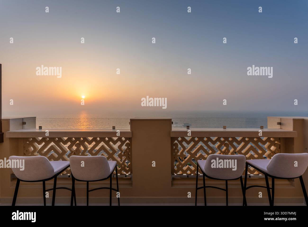 Lussuosa terrazza dell'attico con moderni posti a sedere all'aperto che si affaccia su un tramonto dorato sul Golfo Persico, soggiorno di prima qualità sul lungomare di Dubai, United Ara Foto Stock